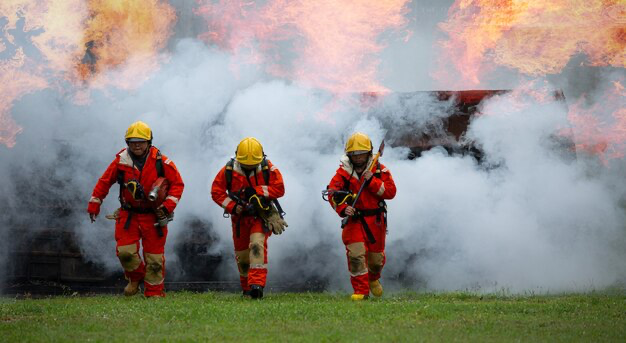 Una squadra di vigili del fuoco corre fuori dal fumo