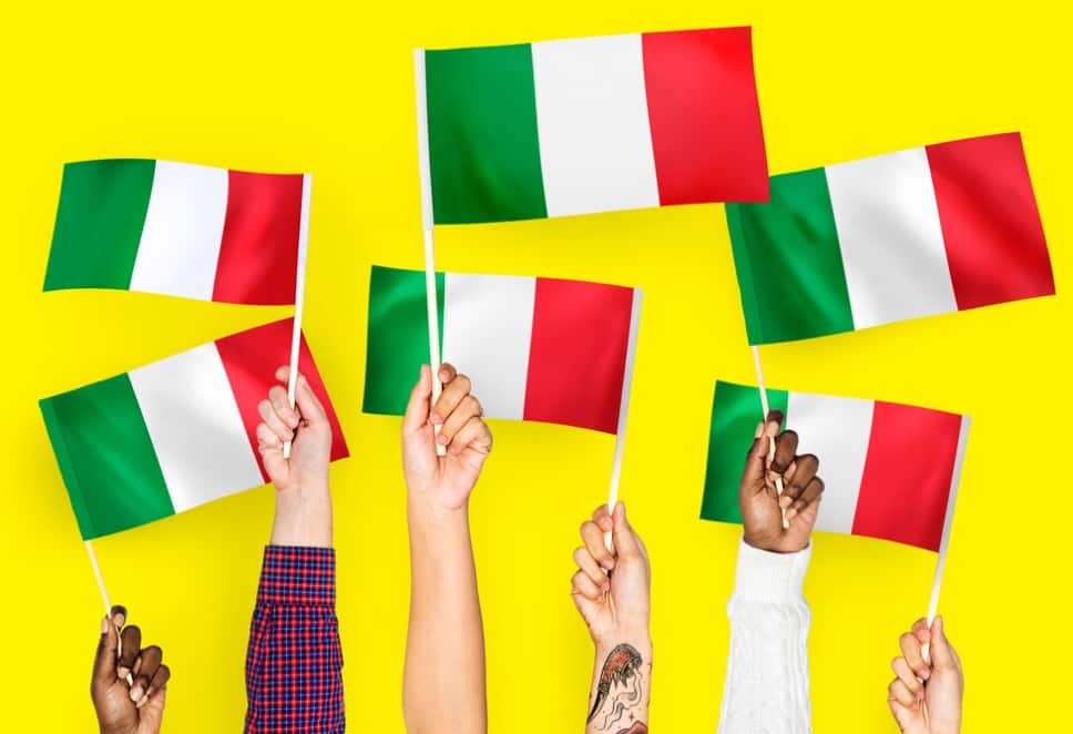 Mani multiple che tengono bandiere italiane su uno sfondo giallo