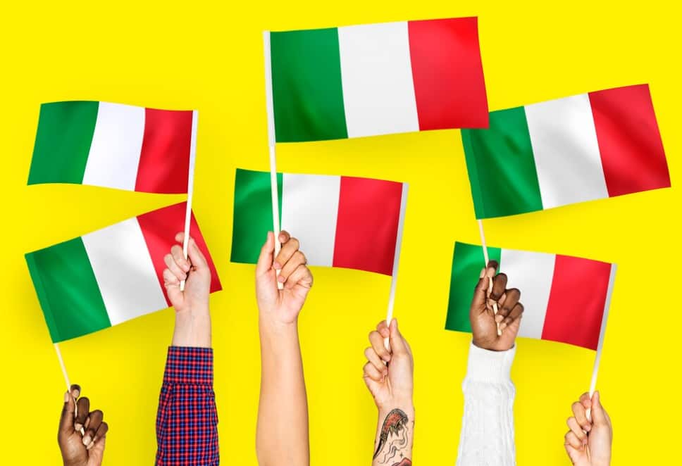 Mani multiple che tengono bandiere italiane su uno sfondo giallo