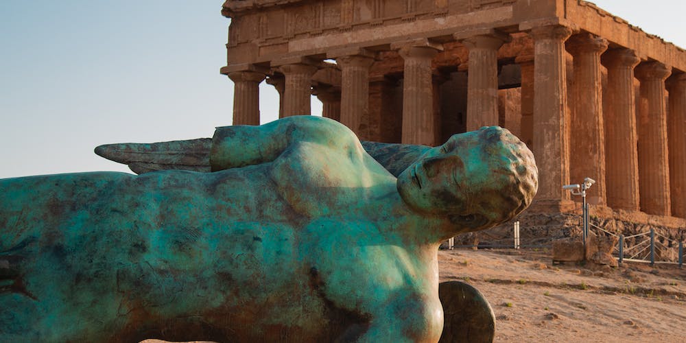 Statua caduta accanto ad un edificio con colonne